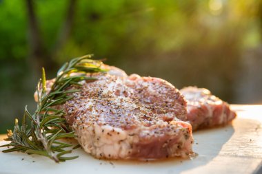 Biberiyeli, zeytinyağlı ve fotokopi alanına yakın bir plastik tabakta çiğ domuz bifteği. Karabiberli domuz bifteği ve viski restorantta popüler bifteklerden biridir..