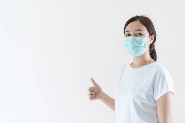 Grip ve virüsü korumak için yüzüne koruyucu hijyen maskesi takan Asyalı genç çekici bir kadın. Hasta kadın portresi ve sarı arkaplan nezlesi. Covid19 ve Coronavirus.