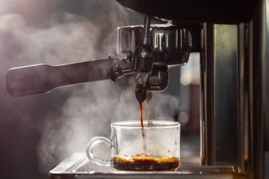 Barista küçük bir kahve dükkanında yüksek basınçlı espresso makinesi kullanarak kahve yapıyor. Kahve dükkanındaki kahve makineleri..