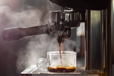 Barista brewing the espresso coffee by using high pressured espresso machine in a small coffee shop. Coffee machinery in coffee shop. clipart