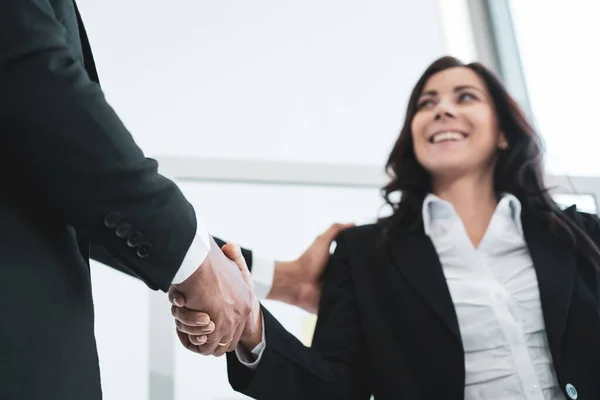 Asian and caucasian ethnicity businesspeople doing a handshake together after done and completed business negotiation. Trust in business partnership and colleague. Successful in business concept.