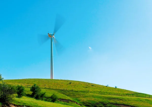 Windmill spinning on green valley — Stock Photo, Image