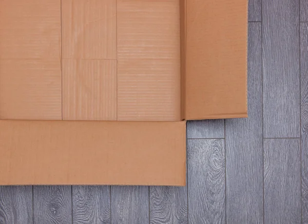 Colocação plana de caixa de papelão aberta vazia na superfície de madeira — Fotografia de Stock