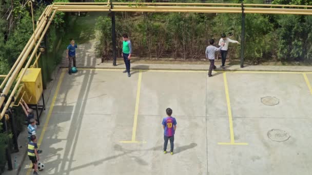 Crianças jogando futebol no estacionamento urbano — Vídeo de Stock