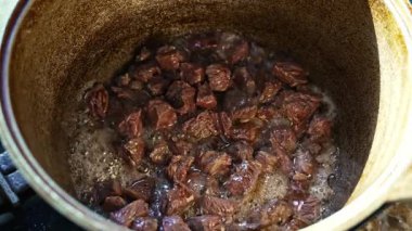 Kazan kazanda orta boy et pişirme, kaymak kaşıkla karıştırma, sıcak yağ cızırtısı, buhar ve duman, otantik Özbek mutfağı, ev yapımı yemek hazırlama 4K video kaydı