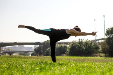 Hatha yoga uygulamak genç atletik kadın giyiyor tozluk ve helezon duruşlar
