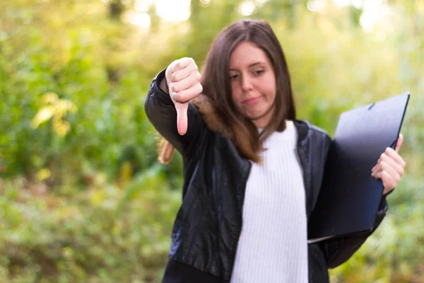 Woman or young caucasian european college girl or student with folder with negative gesture because she has failed the final exam and does not like to study