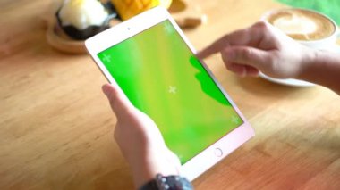 Tablet chroma anahtar yeşil ekran. Çalışma ya da online alışveriş kafe ya da restoran kadın elini tutarak tablet ve başka birini dokunmatik el ya da üstünde belgili tanımlık perde, 4 k görüntüleri slayt.