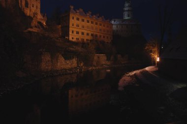 Cesky Krumlov Şatosu gece aydınlandı ve Çek Cumhuriyeti 'nin UNESCO miras alanı olan nehre yansıdı 