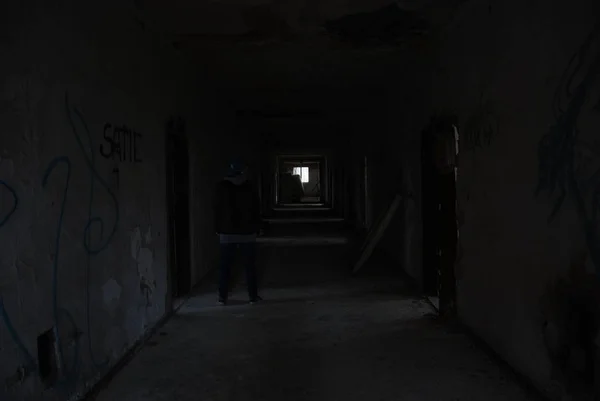 放棄された崩壊ビル ウルベックスの暗い廊下に立つ裏側からの人 — ストック写真