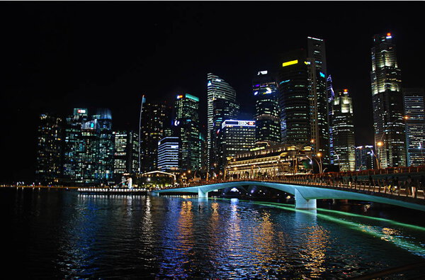 Modern architecture around Marina Bay in Singapore city center illuminated at night