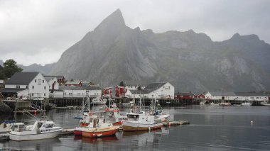 Arka planda sivri kaya ile Lofoten takımadalar üzerinde geleneksel balıkçı köyü 