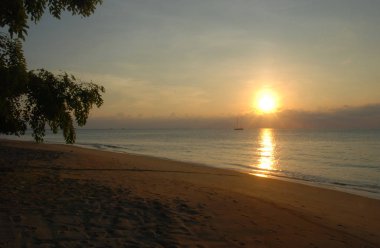 Gün batımında Tioman adasının Tekek köyü plajı