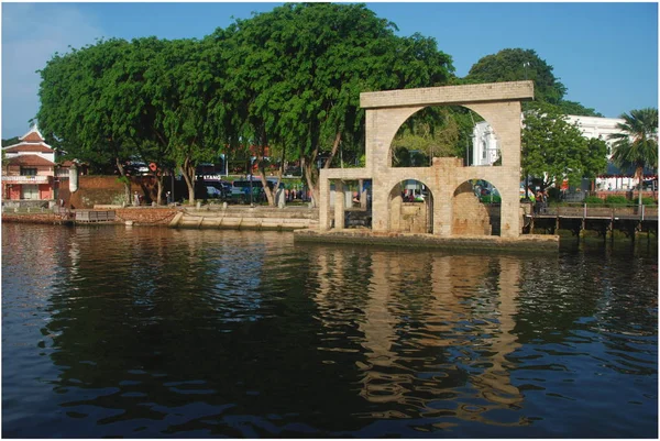 Water wheel in Malacca city reflected in Malacca River going through historical city center, Malaysia