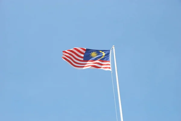 旗杆上的马来西亚国旗在风中飘扬 背景是晴朗的蓝天 — 图库照片