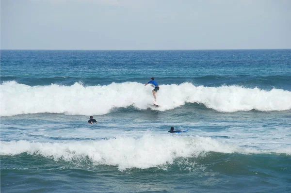 Surfing on sea waves by Pantai Batu Bolong beach of south Bali, Indonesia