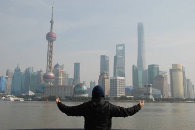 Bund'da gökdelenlerle dolu Şangay panoramasını bakan bir adam, Çin