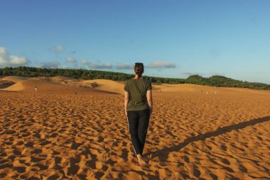 Mui Ne, Vietnam 'ın Kızıl Kum tepelerinde duran bir kadın. 
