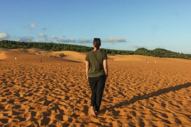 Mui Ne, Vietnam 'ın Kızıl Kum tepelerinde duran bir kadın. 