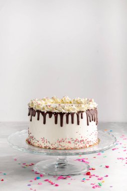 Doğum günü damla katmanlı kek çikolata ganache ve parti dekor beyaz bir zemin üzerine sprinkles. Yatay. Uzay kopyalayın. Kutlama kavramı. Trendy damla kek.