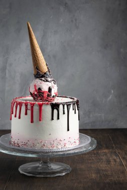 Damla koni pasta sprinkles üzerinde gri bir arka plan ile. Pasta dekorasyonu yapma. Uzay kopyalayın. Kutlama kavramı. Trendy kek. Dikey.
