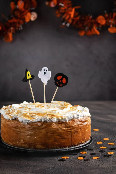 Classic Pumpkin Cheesecake with Marshmallow Meringue Topping decorated with Halloween toppers. Dessert for Halloween and Thanksgiving. Space for text. Vertical. Selective focus.
