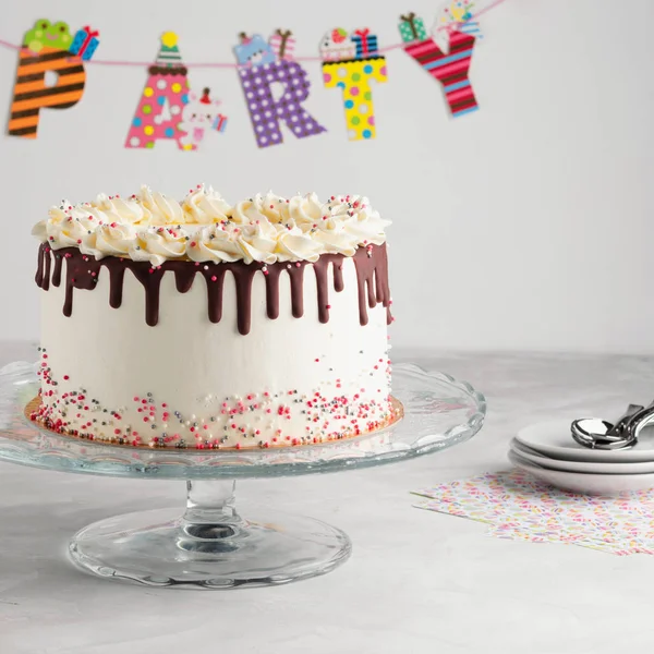 誕生日点滴層ケーキ チョコレートのガナッシュとパーティーの装飾と白い背景の上に振りかける 領域をコピーします お祝いのコンセプトです トレンディな点滴ケーキ — ストック写真