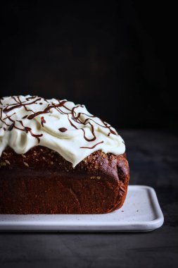 Çikolata somun kek frosting ve kopya alanı ile koyu arka plan üzerinde çikolata eritme krem şanti ile dekore edilmiş.