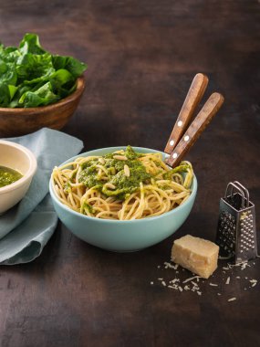 Ispanak pesto soslu makarna spagetti, kapta ceviz ve taze çiğ ıspanak yaprakları. koyu arka plan kopya alanı ile. Sağlıklı beslenme, vejetaryen yemek.