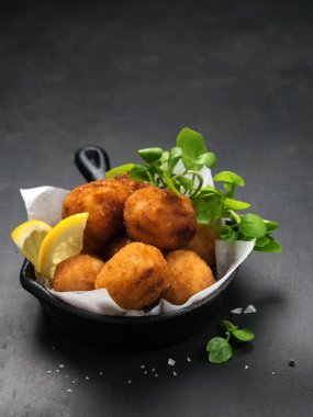 Ekmekli yapılan İspanyol bacalao kroket demir tavada kızarmış morina tuzlu ve geleneksel tapas veya aperatif olarak görev yaptı. Kopya alanı ile koyu arka plan.