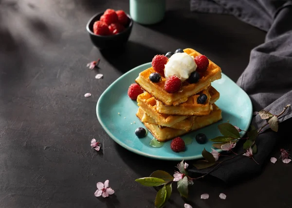 Frisch gebackene Waffeln mit Himbeeren, Beeren, Honig und Kaffee zum Frühstück oder Brunch auf dunklem Hintergrund mit Kopierraum. hausgemachtes Dessertkonzept. — Stockfoto