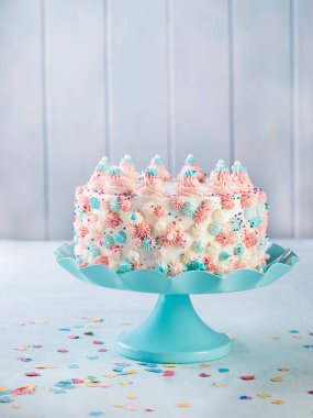 Vanilya buttercream tarafsız bir arka plan üzerinde renkli sprinkles ile doğum günü pastası.