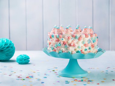 Vanilya buttercream tarafsız bir arka plan üzerinde renkli sprinkles ile doğum günü pastası.