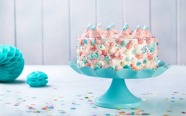 Vanilya buttercream tarafsız bir arka plan üzerinde renkli sprinkles ile doğum günü pastası.