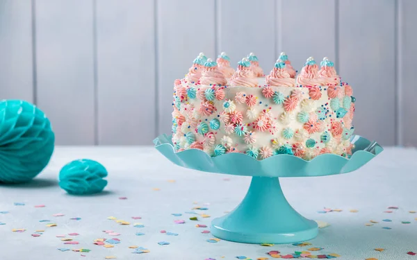 Gâteau d'anniversaire à la crème beurre vanille avec des saupoudres colorées sur un fond neutre . — Photo