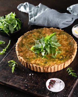 Ispanak, arugula ve peynir feta ile Quiche, copyspace ile koyu arka plan üzerinde gruyere. Ev yapımı, geleneksel Fransız quiche pasta.