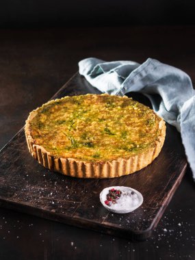 Ispanak, arugula ve peynir feta ile Quiche, copyspace ile koyu arka plan üzerinde gruyere. Ev yapımı, geleneksel Fransız quiche pasta.