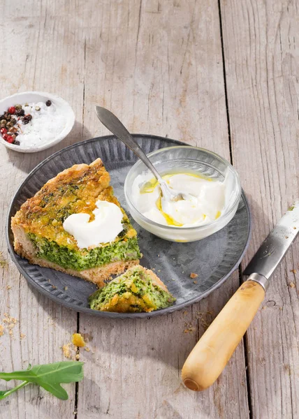 Snijd quiche op een bord met rucola, ui, spinazie, mozzarella, feta en saus op rustieke achtergrond, Top uitzicht, ruimte voor zelfgemaakte, traditionele Franse quiche Pie. — Stockfoto