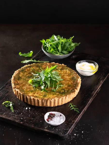 Quiche met spinazie, rucola en kaas feta, Gruyere op donkere achtergrond met copyspace. Zelfgemaakte, traditionele Franse quiche Pie. — Stockfoto
