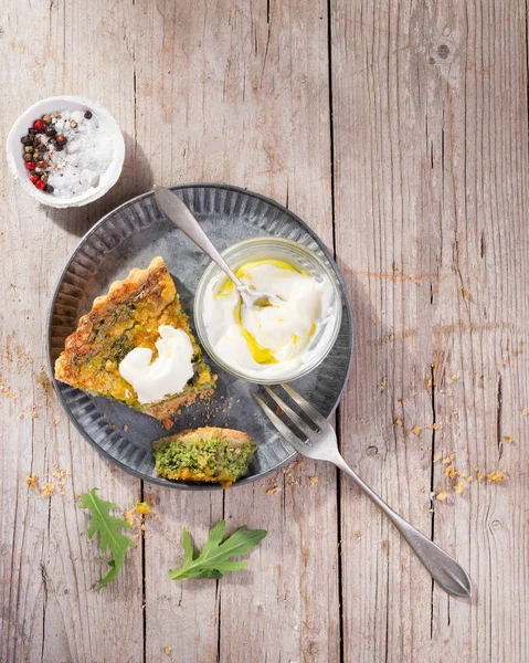 Snijd quiche op een bord met rucola, ui, spinazie, mozzarella, feta en saus op rustieke achtergrond, Top uitzicht, ruimte voor zelfgemaakte, traditionele Franse quiche Pie. — Stockfoto