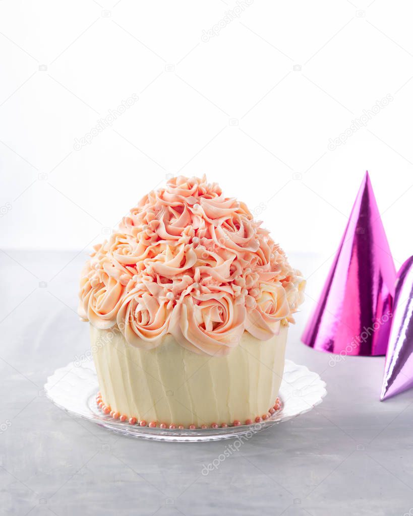 Delicious birthday cake cupcake and party hat, colorful confetti, on white background with space for text. Celebration party background concept.