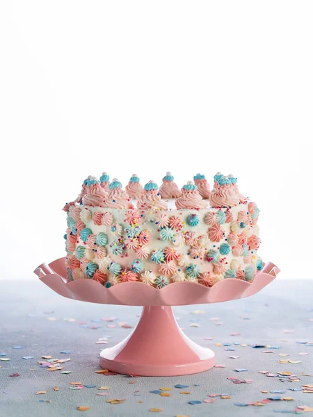 Colorful blue and pink Birthday cake with sprinkles over White Background and confetti. Celebration Child\'s birthday party concept. Space for text.