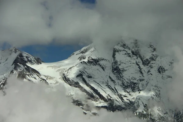 high mountains in the snow, blue sky in the clouds, cold, frost, wind, climbing, overcoming yourself