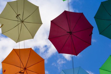 gökyüzünde süzülen renkli şemsiyeler