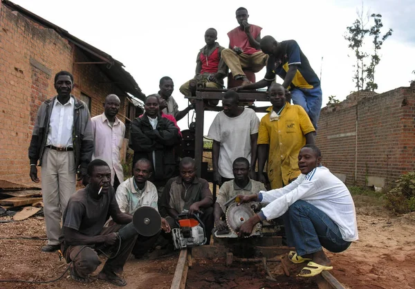 Lubumbashi, Demokratik Kongo Cumhuriyeti, yaklaşık Mayıs 2006: Terk edilmiş bir fabrikada kameraya gülümseyen marangozlar grubu. Şehrin sanayi bölgesinde, şu anda insanların yaşadığı ve çalıştığı birkaç eski fabrika var..