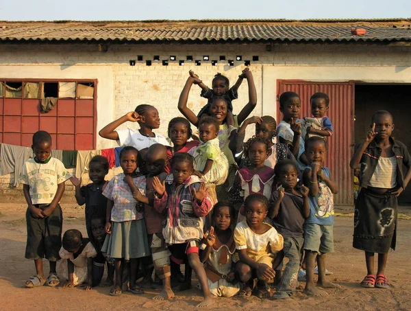 Lubumbashi, Demokratik Kongo Cumhuriyeti, ca. Mayıs 2006: Terk edilmiş bir fabrikanın bahçesinde kameraya poz veren bir grup çocuk. Sanayi bölgesinde, şu anda doğaçlama yaşam alanları olarak kullanılan birkaç eski fabrika var.