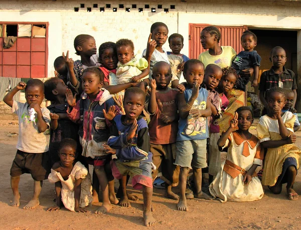 Lubumbashi, Demokratik Kongo Cumhuriyeti, ca. Mayıs 2006: Terk edilmiş bir fabrikanın bahçesinde kameraya poz veren bir grup çocuk ve kadın