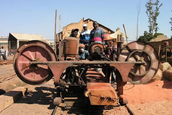 Lubumbashi, Demokratik Kongo Cumhuriyeti, ca. Mayıs 2006: Terk edilmiş bir fabrikanın bahçesinde kameraya poz veren bir grup çocuk ve kadın