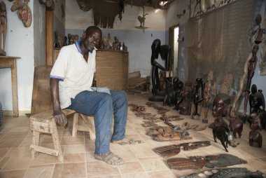 Mbour, Senegal, el sanatları satıcı onun küçük dükkan içinde poz