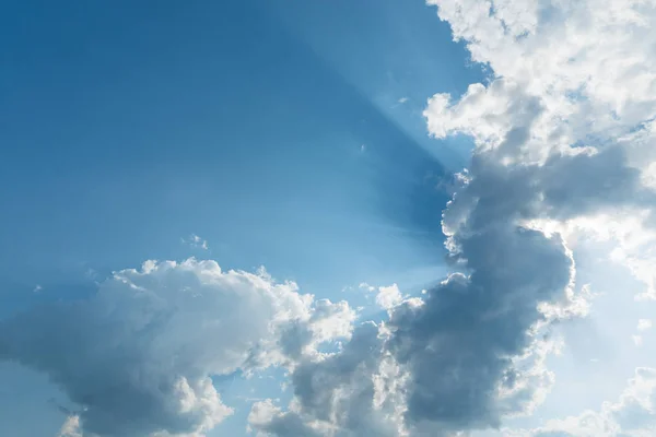 Clouds with sun rays on the blue sky